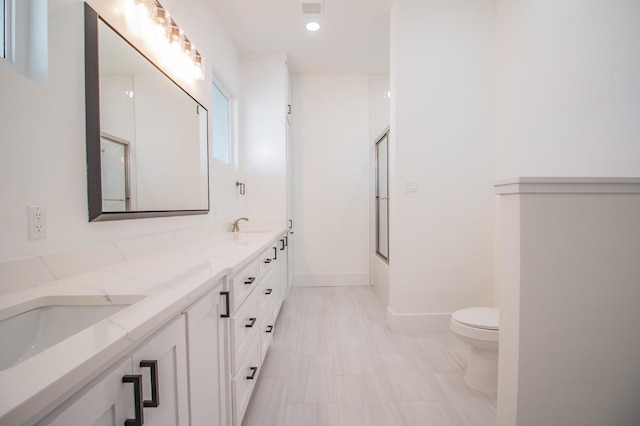 full bathroom featuring enclosed tub / shower combo, vanity, and toilet