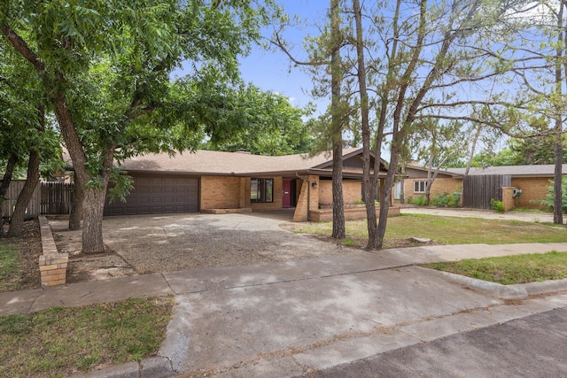 4635 30th St, Lubbock, TX 79410 - view of front facade with an attached garage, driveway, and brick siding