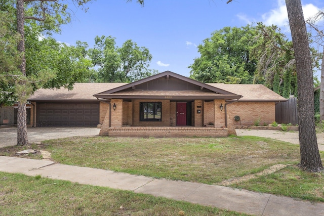 4635 30th St, Lubbock, TX 79410 - ranch-style home featuring covered porch, concrete driveway, an attached garage, brick siding, and roof with shingles