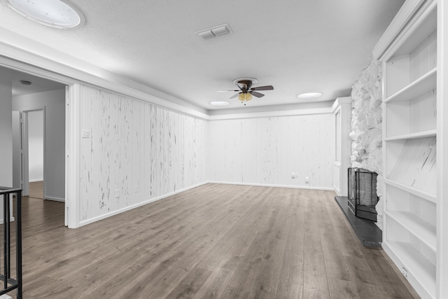 4635 30th St, Lubbock, TX 79410 - unfurnished living room with a ceiling fan, wood finished floors, and a fireplace