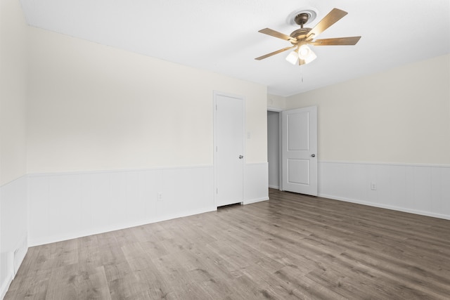 4635 30th St, Lubbock, TX 79410 - empty room featuring wood finished floors, a wainscoted wall, and ceiling fan