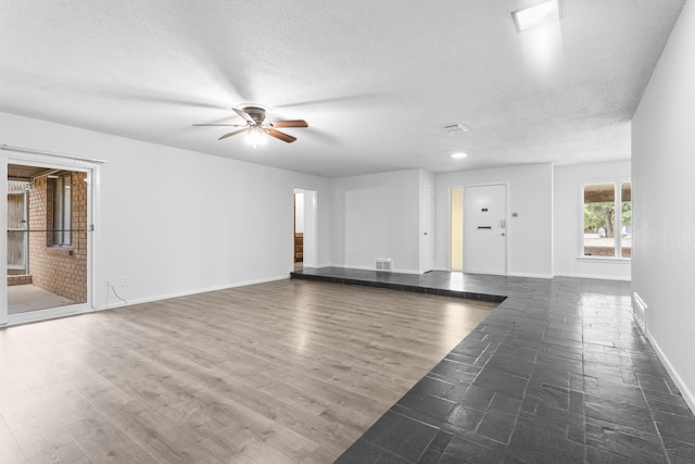 4635 30th St, Lubbock, TX 79410 - unfurnished living room featuring ceiling fan, a textured ceiling, and wood finished floors