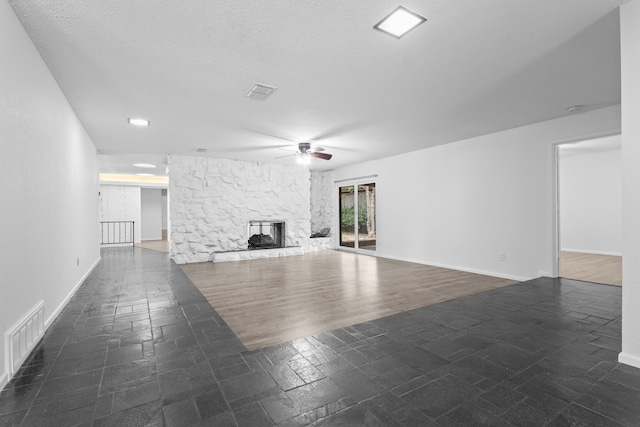 4635 30th St, Lubbock, TX 79410 - unfurnished living room with a ceiling fan and a stone fireplace