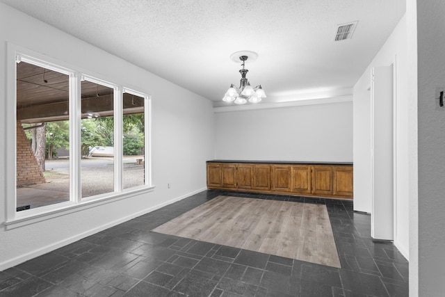 4635 30th St, Lubbock, TX 79410 - unfurnished dining area featuring a chandelier and a textured ceiling