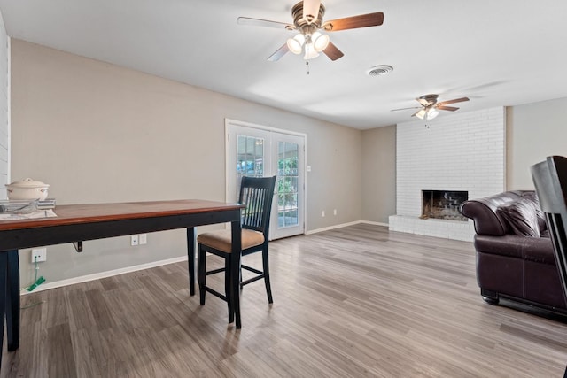 office space featuring hardwood / wood-style floors, a fireplace, and ceiling fan