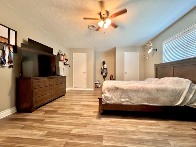 bedroom featuring ceiling fan, a textured ceiling, and light wood-type flooring