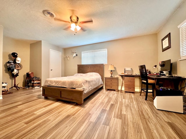 bedroom featuring ceiling fan, a textured ceiling, and light wood-type flooring