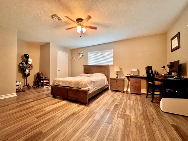 bedroom featuring ceiling fan, light hardwood / wood-style floors, and a textured ceiling