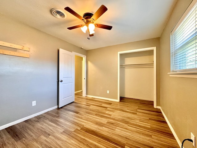 unfurnished bedroom with light hardwood / wood-style flooring, a closet, and ceiling fan