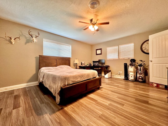 bedroom featuring wood-type flooring, ceiling fan, and a textured ceiling