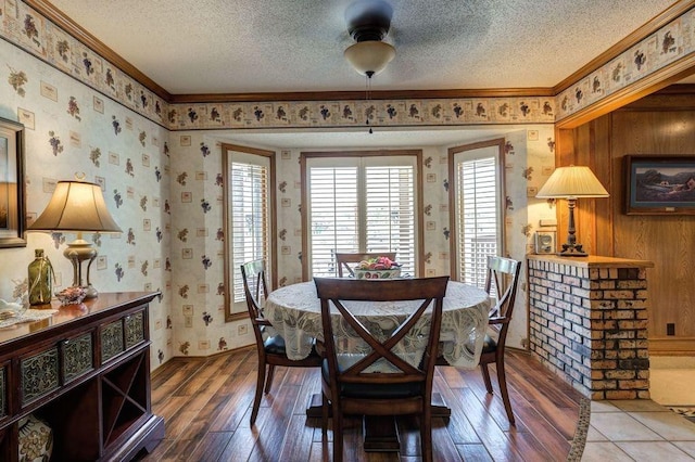 dining space with ornamental molding, hardwood / wood-style floors, and a textured ceiling