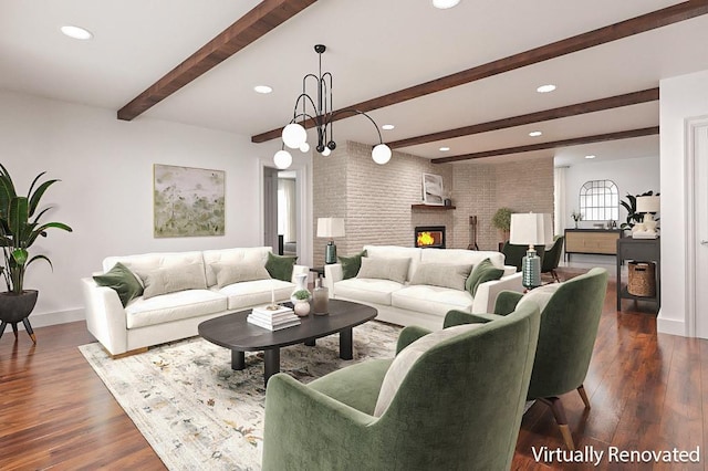 living room featuring beam ceiling, dark hardwood / wood-style floors, a notable chandelier, brick wall, and a fireplace