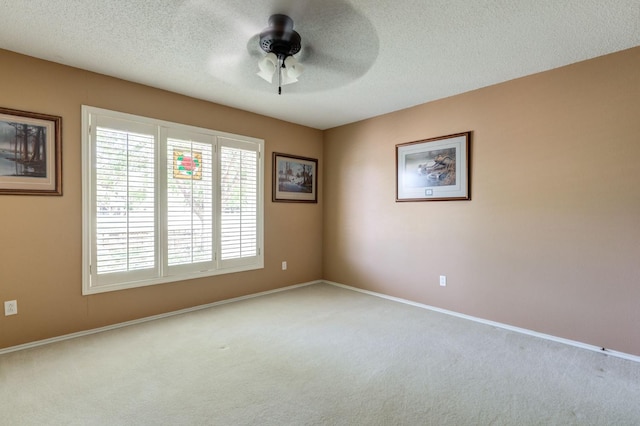 unfurnished room featuring light carpet, a textured ceiling, and ceiling fan