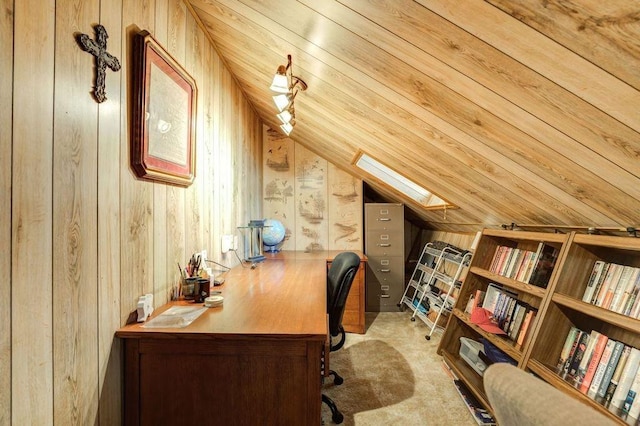 home office featuring vaulted ceiling with skylight, light colored carpet, and wood walls