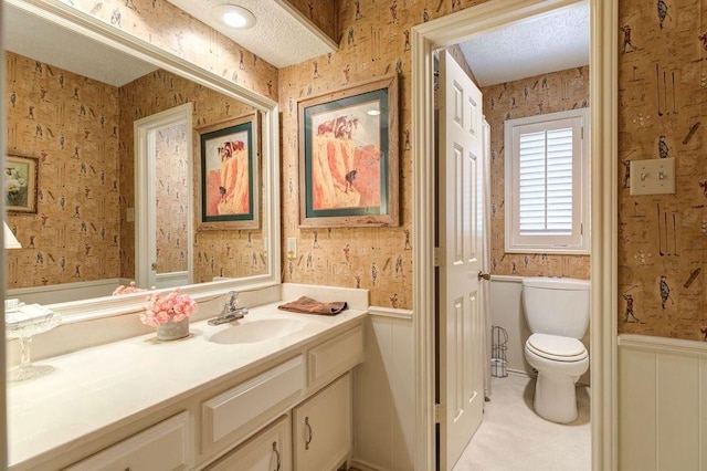 bathroom featuring vanity, a textured ceiling, and toilet