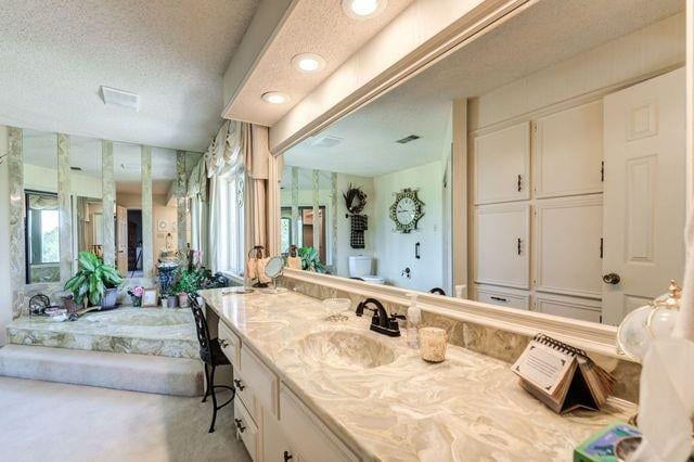 bathroom with vanity, a bathtub, and a textured ceiling