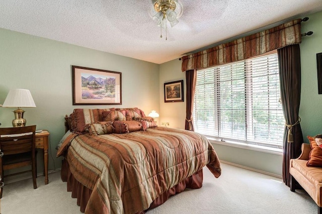 carpeted bedroom featuring ceiling fan and a textured ceiling