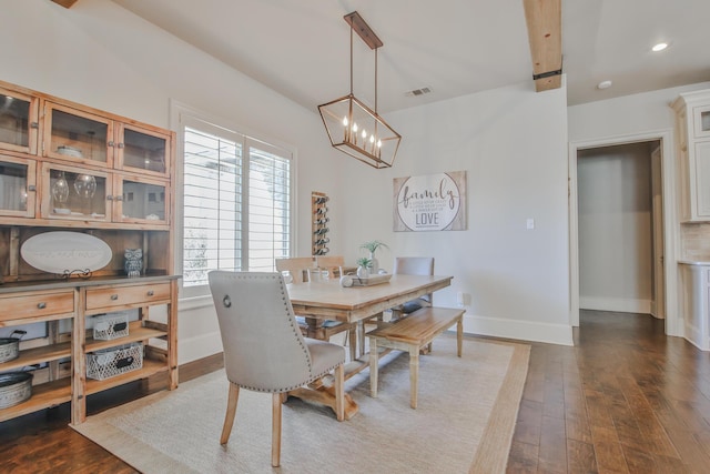 dining space with dark hardwood / wood-style floors and an inviting chandelier