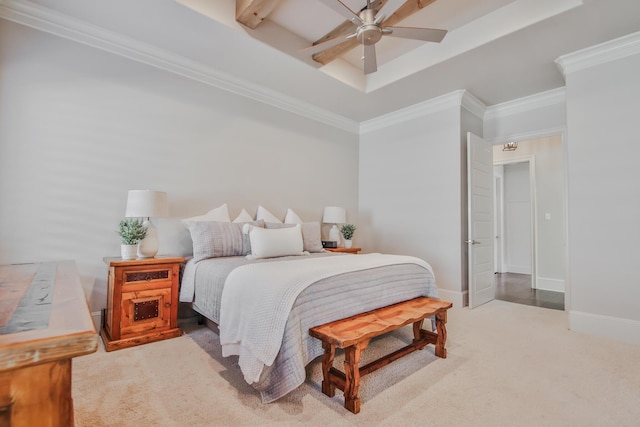 carpeted bedroom featuring crown molding, ceiling fan, and a tray ceiling