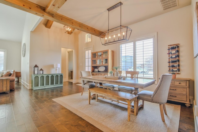 dining space with beamed ceiling, a healthy amount of sunlight, dark hardwood / wood-style floors, and a notable chandelier