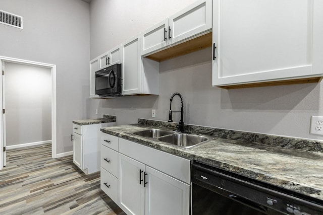 kitchen with light wood-type flooring, white cabinets, sink, and black appliances