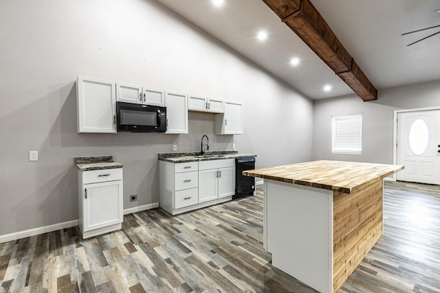 kitchen featuring white cabinets, wood counters, beamed ceiling, and black appliances