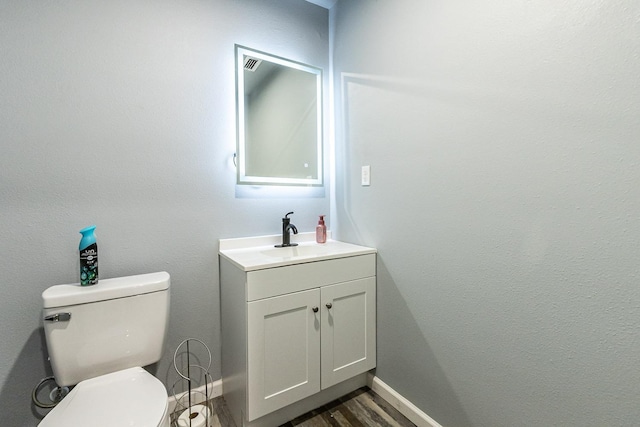 bathroom with vanity, toilet, and hardwood / wood-style floors