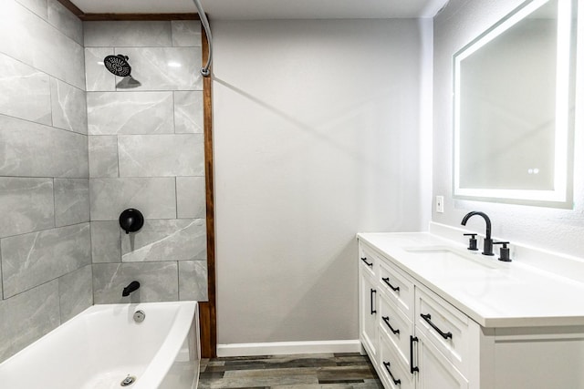 bathroom with vanity, tiled shower / bath combo, and hardwood / wood-style flooring