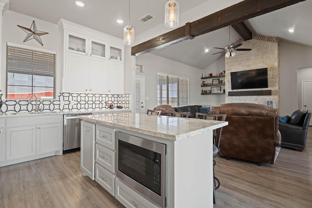 kitchen with built in microwave, dishwasher, visible vents, and light wood-style floors
