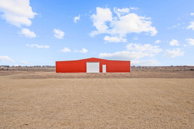 view of pole building featuring fence and a rural view