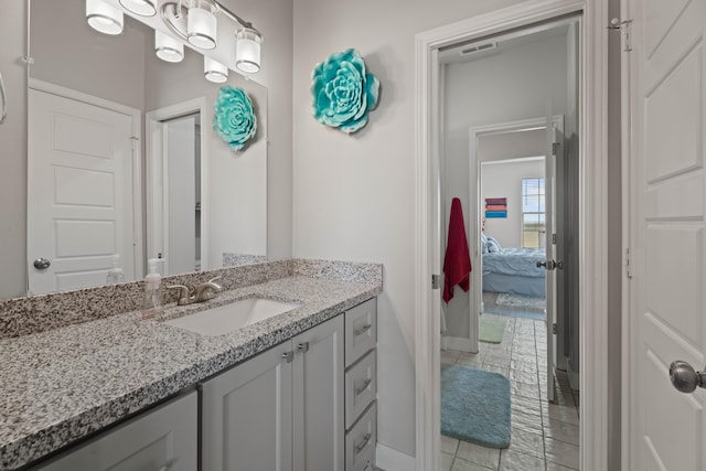 bathroom featuring tile patterned flooring, ensuite bathroom, vanity, baseboards, and visible vents