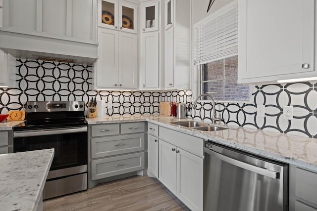 kitchen with white cabinetry, tasteful backsplash, appliances with stainless steel finishes, and a sink