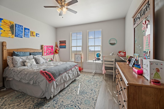 bedroom with wood finished floors, a ceiling fan, and baseboards