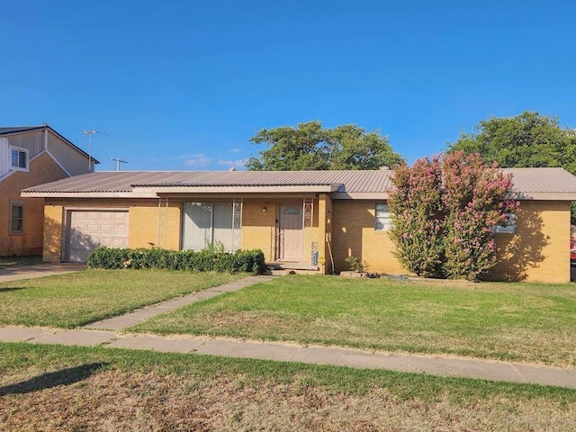 single story home with metal roof, brick siding, an attached garage, and a front yard