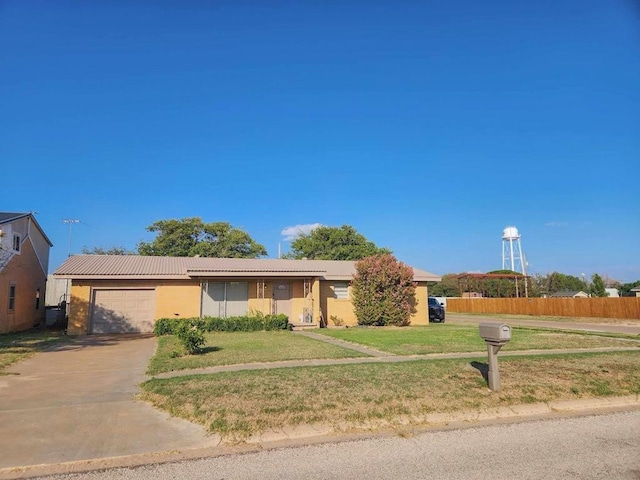 ranch-style home featuring a garage, a front yard, driveway, and fence