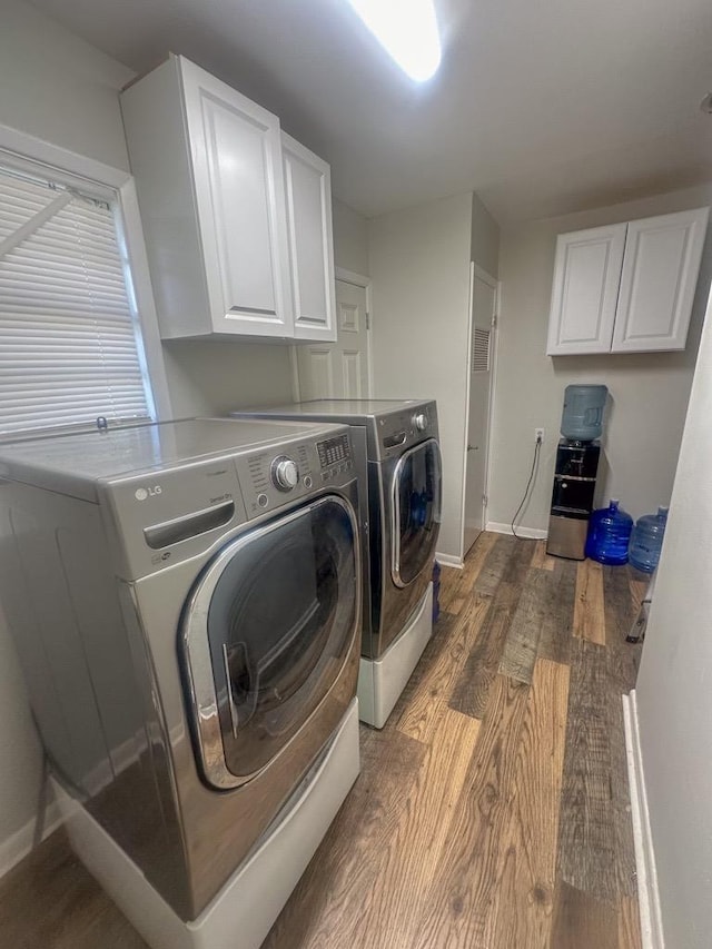 laundry room with wood finished floors, cabinet space, baseboards, and separate washer and dryer