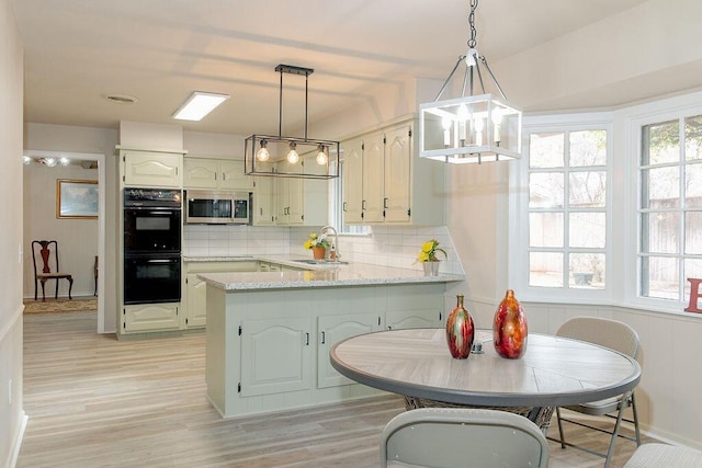 kitchen featuring sink, tasteful backsplash, kitchen peninsula, pendant lighting, and black double oven