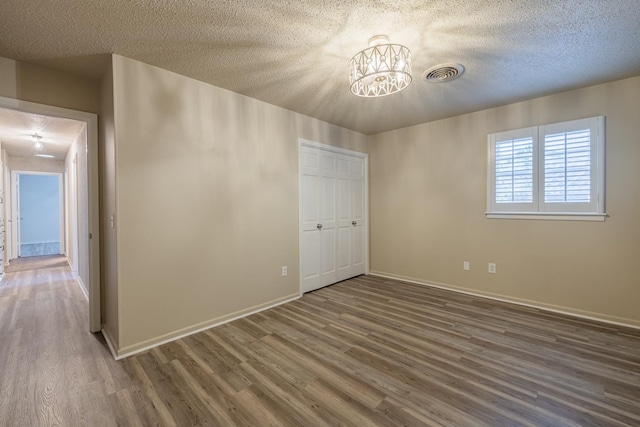 empty room with dark wood-type flooring and a textured ceiling