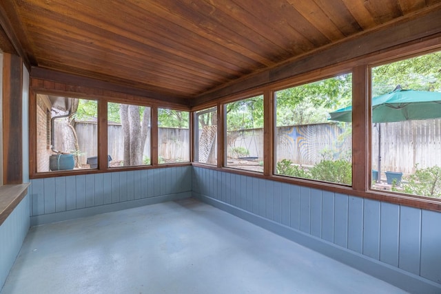 unfurnished sunroom with a healthy amount of sunlight and wood ceiling