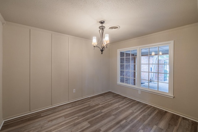 empty room featuring dark hardwood / wood-style flooring, crown molding, a chandelier, and a textured ceiling