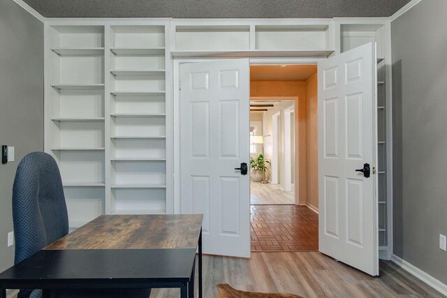 office space with built in shelves and light hardwood / wood-style floors