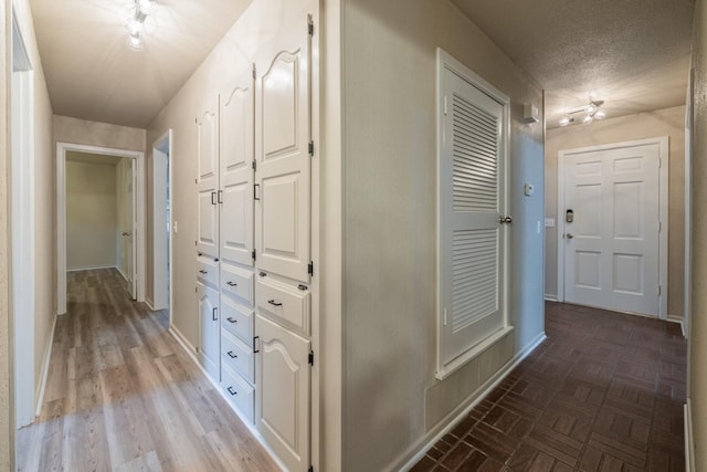 hall featuring a textured ceiling