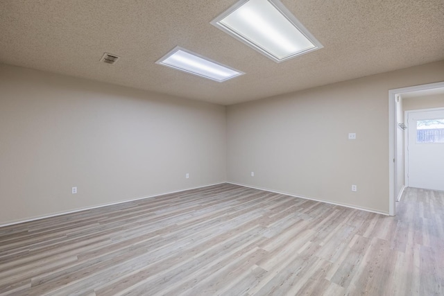 spare room with light hardwood / wood-style flooring and a textured ceiling