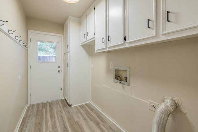 clothes washing area featuring light hardwood / wood-style floors and cabinets