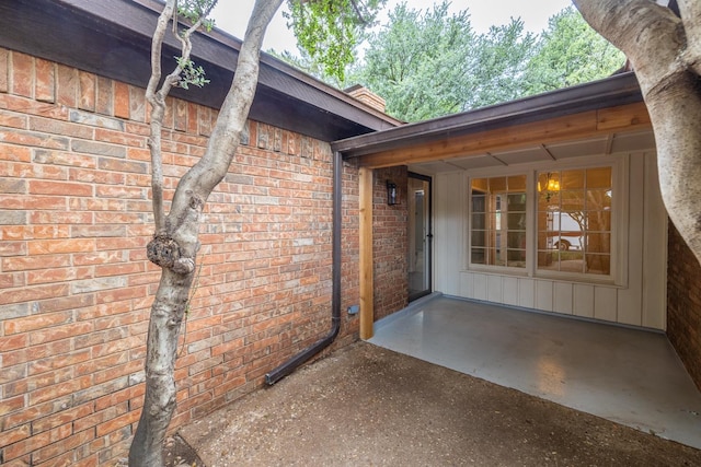 view of exterior entry with a patio area