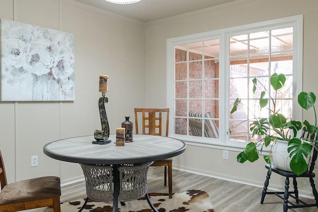 dining room featuring light hardwood / wood-style flooring and ornamental molding