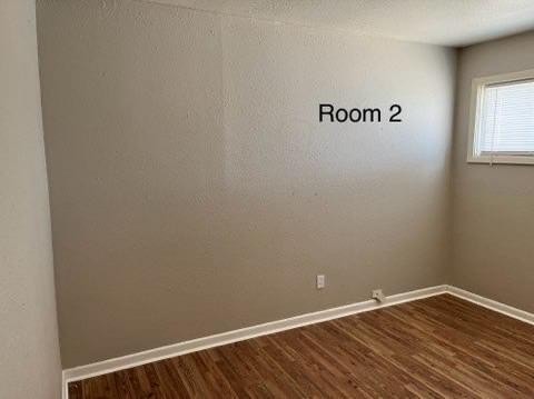 spare room with dark hardwood / wood-style flooring