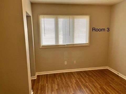 empty room featuring dark wood-type flooring and a wealth of natural light