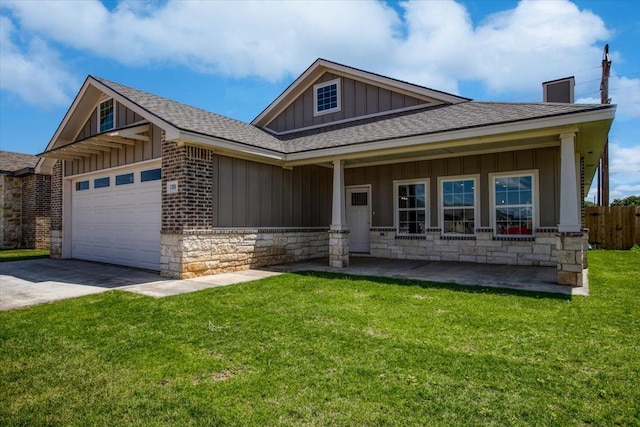 view of front of property featuring a garage, covered porch, and a front yard