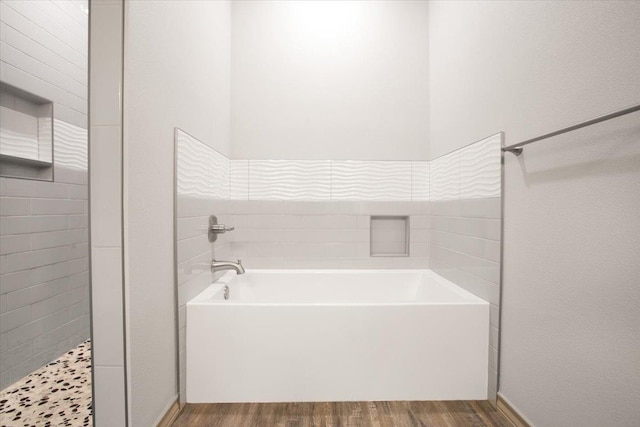 bathroom with hardwood / wood-style flooring and a tub